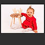 toddler, child, red_dress, smiling, sitting, wooden_chair, fur_seat, antler_design, white_background, playful, happy, indoors, cute, person, baby, studio_photo, young_child, fashion, fun, small_furniture