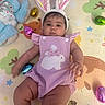 baby, bunny_ears, romper, plush_toy, play_mat, easter_eggs, pink, lavender, child, infant, cute, indoors, toy, colorful, face, person, holiday, festive, soft_toy, lying_down