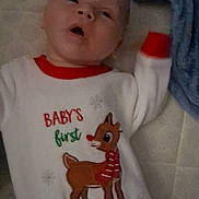 Annabelle joined the competition — help win amazing prizes! baby, infant, onesie, christmas, holiday, reindeer, blanket, clothing, cute, lying_down, indoor, soft, cozy, child, sleepwear, festive, person, face, expression, bed