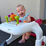 Alma a rejoint le concours — aidez-le/la à gagner de superbes lots ! baby, background, child, clothing, colorful, cute, expression, face, footwear, happy, indoor, infant, joyful, person, plastic, play, seat, smile, toy, walker