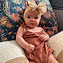 baby, bow, child, closeup, comfortable, couch, cute, decor, expression, fabric, headband, indoor, infant, pattern, person, pillow, plush, portrait, romper, sitting