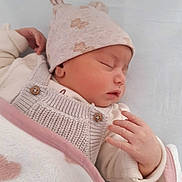 Rym a rejoint le concours — aidez-le/la à gagner de superbes lots ! baby, infant, newborn, sleeping, blanket, hat, knit_overall, hand, bed, sheet, cozy, portrait, closeup, soft_texture, finger, skin, peaceful, nursery, pink, beige