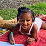 Edene participe au concours pour gagner de l'argent avec cette photo : child, smiling, towel, outdoor, grass, drawing, pen, paper, plush_toy, teddy_bear, book, nature, happy, play, relaxing, barefoot, summer, young_child, casual_clothing, recreation