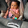Edene participe au concours pour gagner de l'argent avec cette photo : baby, child, car_seat, seat_belt, toy, pink_cloth, curly_hair, indoor, person, infant, serious_expression, car_interior, safety, closeup, cute, young_child, seat_handle, hands, clothing, portrait