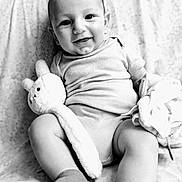 Bennett a rejoint le concours — aidez-le/la à gagner de superbes lots ! baby, smile, onesie, plush_toy, blanket, socks, infant, face, happy, cute, child, portrait, black_and_white, soft_toy, sitting, fabric, cozy, indoor, young_child, cuddly