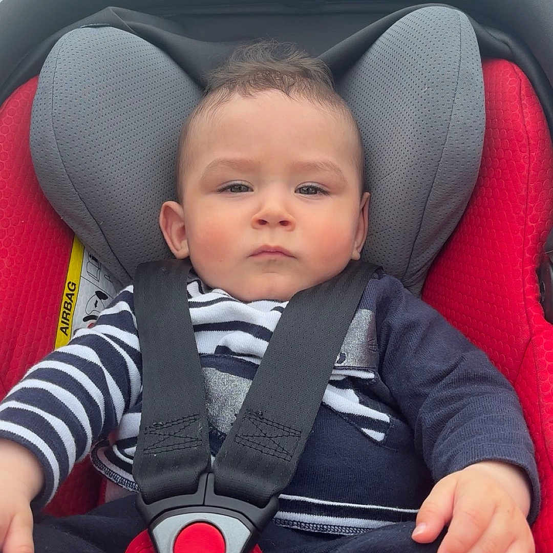 Ezio a rejoint le concours — aidez-le/la à gagner de superbes lots ! accessories, baby, clothing, coat, cushion, face, head, homedecor, jacket, lifejacket, outdoors, pants, person, photography, portrait, sleeping, t_shirt, transportation, vehicle, vest