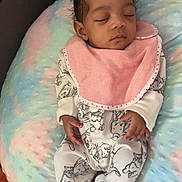 Isïah a rejoint le concours — aidez-le/la à gagner de superbes lots ! baby, sleeping, infant, onesie, bib, pastel_colors, cushion, blanket, animal_print, hand, peaceful, resting, soft_texture, cozy, indoor, child, portrait, cute, relaxation, young