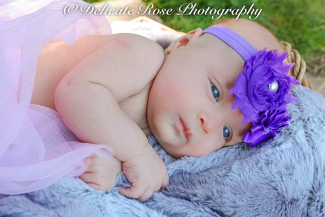 Jupiter is registered to the contest to win money with this photo: baby, beauty, cheek, child, eye, face, hair_accessory, head, headgear, headwear, lavender, lilac, lip, nose, person, photograph, photography, pink, product, purple