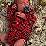 baby, infant, pacifier, red_plaid, sock, ornaments, christmas, holiday, soft_rug, cozy, festive, decorations, cute, lying_down, small, newborn, indoors, celebration, comfort, child