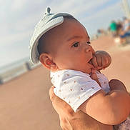 Noham participe au concours pour gagner de l'argent avec cette photo : baby, infant, hand, hat, outdoor, person, skin, cute, child, face, sucking, holding, apparel, clothing, portrait, blurred_background, daylight, expression, young, headwear