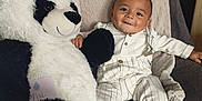 Noham a rejoint le concours — aidez-le/la à gagner de superbes lots ! baby, child, smiling, plush_toy, panda, chair, white_clothing, striped_pants, socks, cute, indoor, cozy, soft_texture, happy, portrait, infant, cuddly, relaxed, seated, toy