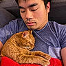 man, cat, sleeping, couch, blanket, indoor, resting, cozy, pet, feline, orange_cat, casual_clothing, relaxation, closeup, home, comfort, nap, fur, human, portrait