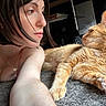 woman, cat, orange_tabby, pet, indoor, carpet, closeup, face, fur, relaxing, portrait, casual, home, lying_down, looking, affection, companionship, arm, necklace, hair