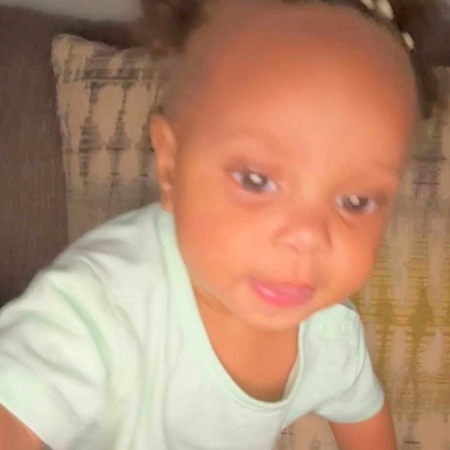 Angel is registered to the contest to win money with this photo: toddler, child, blurred, face, couch, pillow, indoor, person, curious, closeup, young_child, home, casual_clothing, baby, infant, expression, portrait, reaching, soft_lighting, background