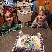 Sarah And Meadow is registered to the contest to win money with this photo: child, birthday_cake, birthday_candles, birthday_crowns, table, room, cake, princesses, smile, celebration, happy, party, indoor, furniture, person, young_children, candles, clothing, hair, face