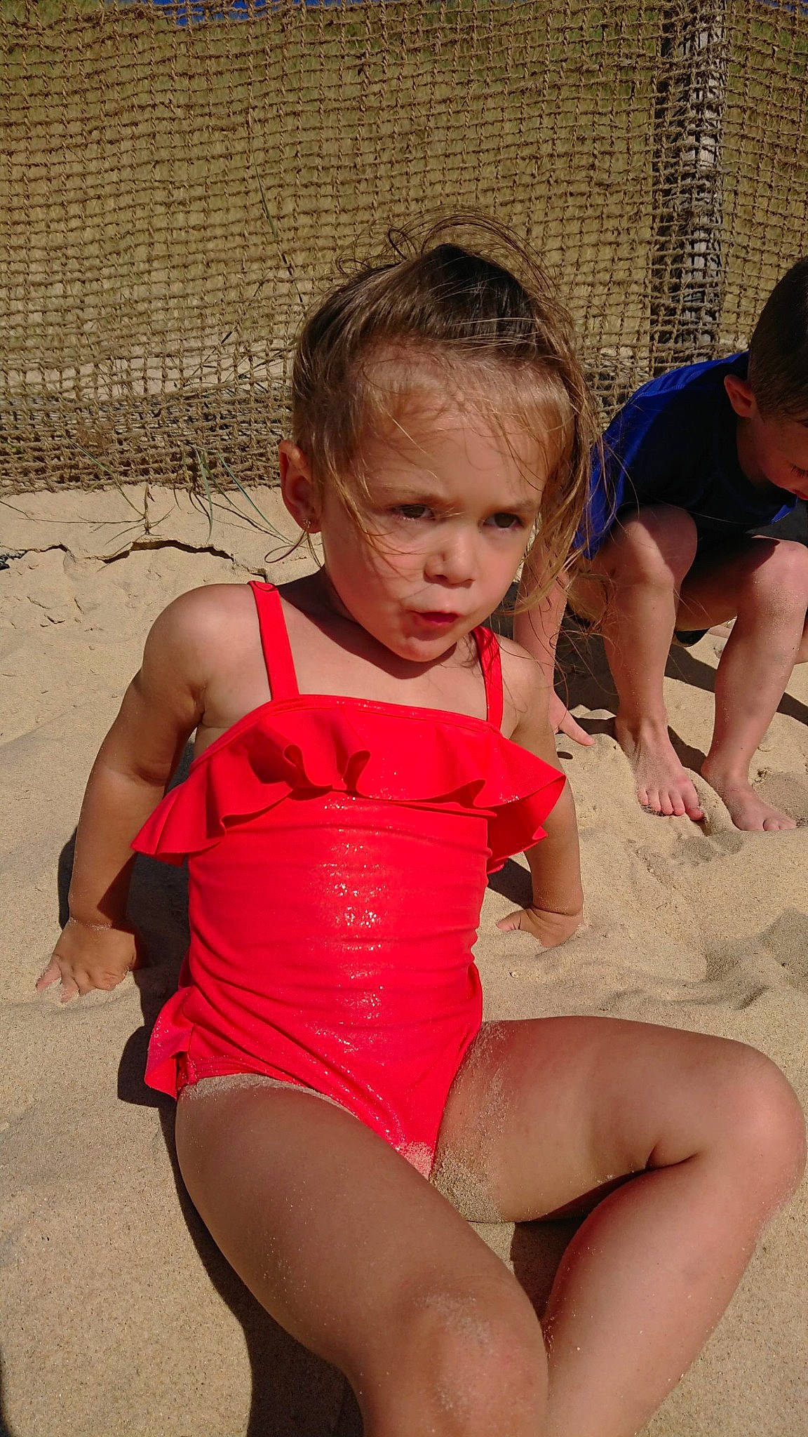 Enola a rejoint le concours — aidez-le/la à gagner de superbes lots ! baby_toddler_clothing, barefoot, child, foot, fun, hand, head, human_body, leg, mammal, one_piece_swimsuit, person, play, sand, summer, swimwear, tankini, thigh, toddler, toe