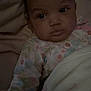 Journi is registered to the contest to win money with this photo: baby, infant, blanket, sleepwear, floral_pattern, face, portrait, cute, child, indoors, soft_lighting, expression, curious, lying_down, warm, comfort, person, newborn, cozy, resting