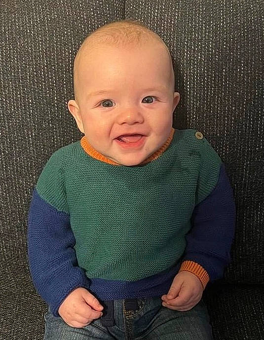 Knox is registered to the contest to win money with this photo: baby, baby_toddler_clothing, cheek, clothing, comfort, flooring, grey, hair, happy, human_body, iris, lip, nose, organ, pattern, person, sleeve, smile, t_shirt, toddler