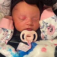 Rayellie-Marie is registered to the contest to win money with this photo: baby, newborn, sleeping, pacifier, headband, black_bow, blanket, car_seat, floral_pattern, pink, clothing, infant, face, peaceful, cute, cozy, child, indoors, closeup, baby_accessory