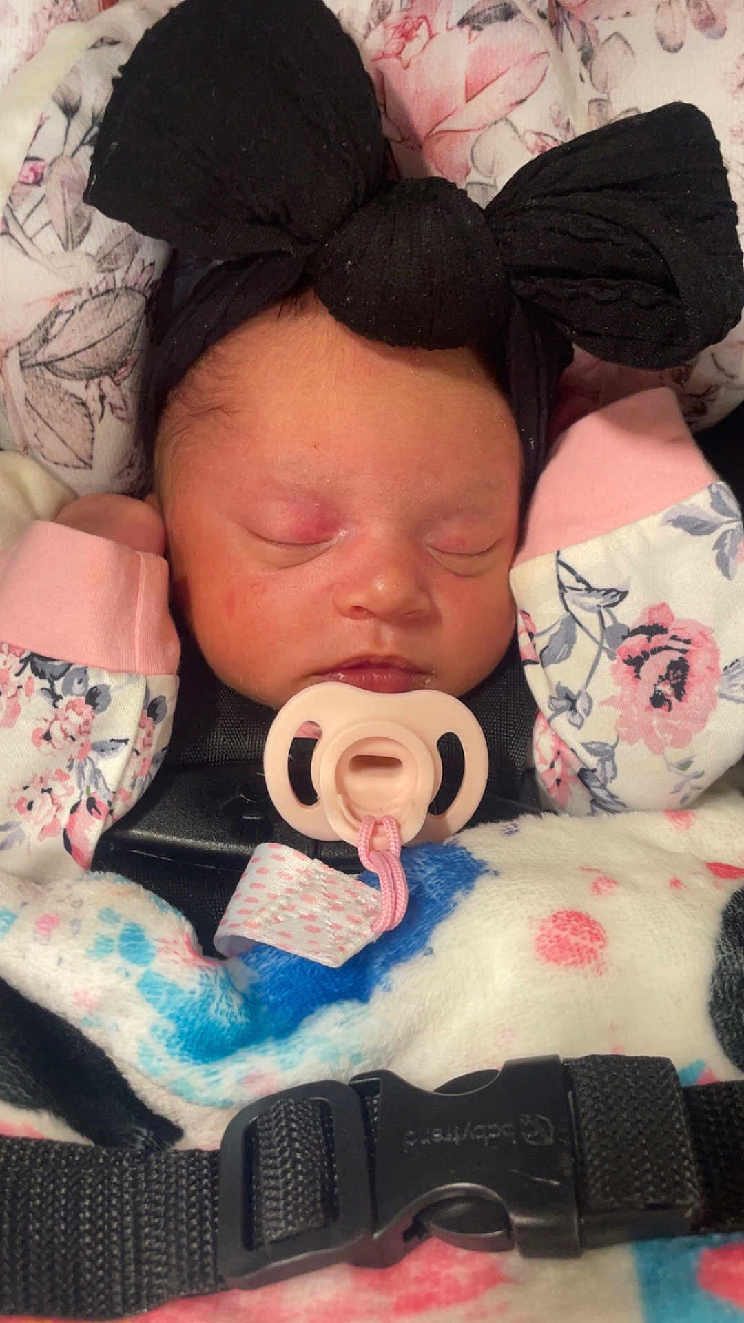 Rayellie-Marie is registered to the contest to win money with this photo: baby, newborn, sleeping, pacifier, headband, black_bow, blanket, car_seat, floral_pattern, pink, clothing, infant, face, peaceful, cute, cozy, child, indoors, closeup, baby_accessory