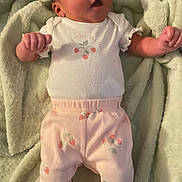 Rayellie-Marie is registered to the contest to win money with this photo: baby, infant, blanket, clothing, onesie, pants, pink, white, face, person, newborn, cute, soft, lying_down, sleepwear, footwear, fist, indoor, portrait, child