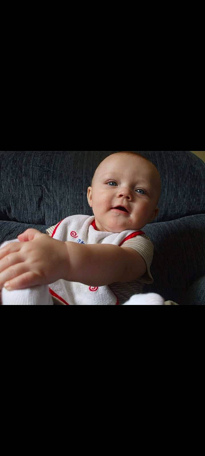 Ashton is registered to the contest to win money with this photo: baby, baby_toddler_clothing, cheek, child, chin, comfort, darkness, elbow, finger, flash_photography, fun, gesture, happy, nail, person, room, sitting, skin, sleeve, thumb