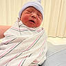 newborn, baby, infant, swaddled, blanket, hat, sleeping, hospital, wrapped, cute, child, person, soft_lighting, indoors, closeup, portrait, small, peaceful, newborn_hat, pink_stripes