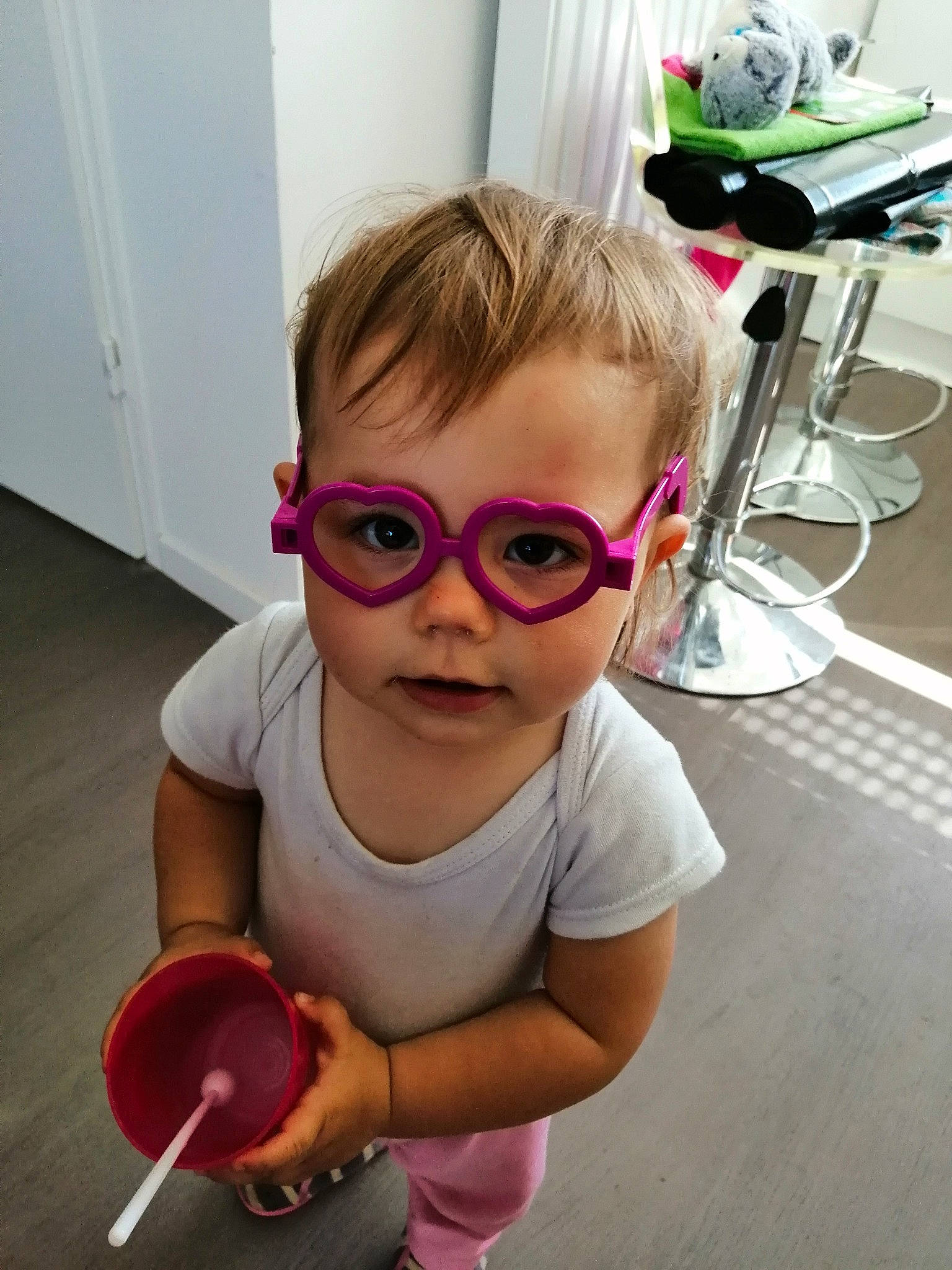 Lily participe au concours pour gagner de l'argent avec cette photo : baby_toddler_clothing, child, door, eyelash, eyewear, flooring, glasses, goggles, hair, happy, head, nose, person, pink, purple, shoe, shoulder, sleeve, sunglasses, toddler