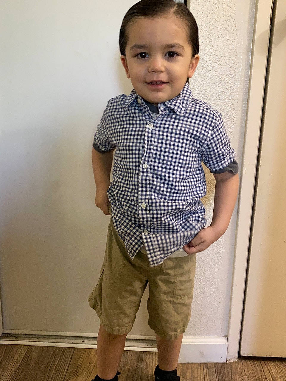 Jasiah is registered to the contest to win money with this photo: baby_toddler_clothing, bermuda_shorts, collar, dress_shirt, elbow, flooring, happy, joint, joy, knee, neck, pattern, person, plaid, shoulder, sleeve, smile, standing, t_shirt, thigh