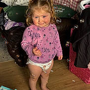 Isabella joined the competition — help win amazing prizes! toddler, child, indoor, standing, pigtails, pink_sweater, unicorn_pattern, diaper, bubbles, wooden_floor, couch, pillows, blanket, basket, toy_box, barefoot, smiling, face, hair, home