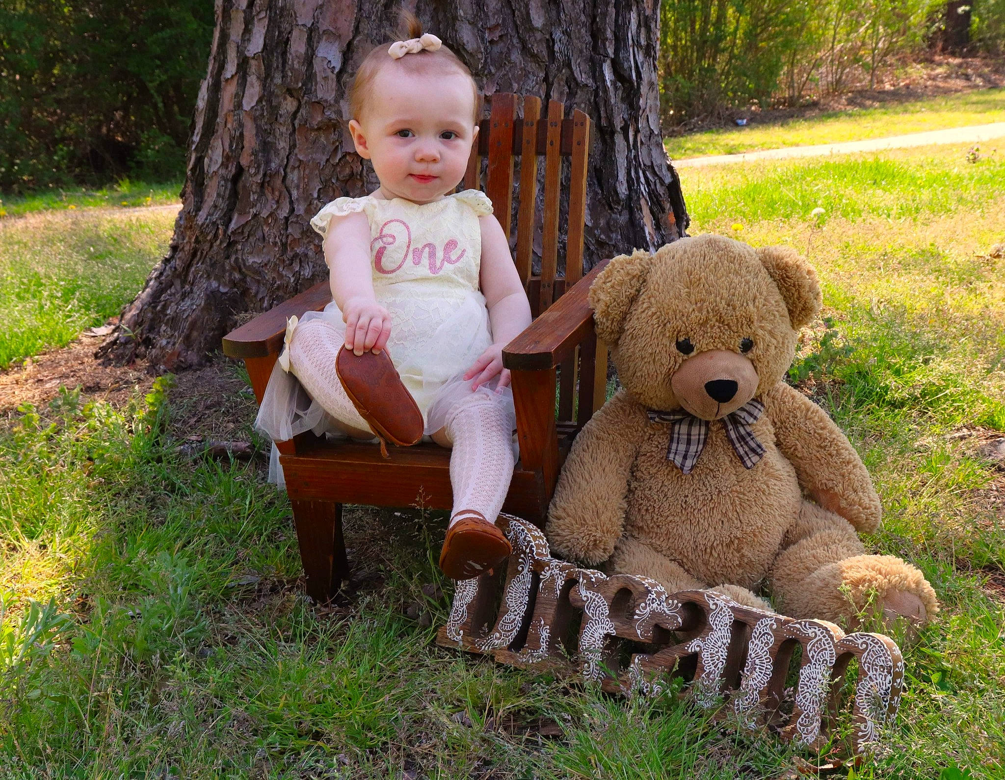 Georgia is registered to the contest to win money with this photo: baby, chair, child, doll, fawn, grass, happy, people_in_nature, person, plant, plush, sitting, soil, stuffed_toy, teddy_bear, terrestrial_animal, toddler, toy, tree, trunk