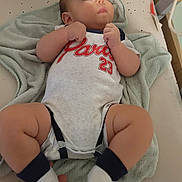 Louka participe au concours pour gagner de l'argent avec cette photo : baby, changing_pad, child, clothing, cute, fabric, face, footwear, hand, indoor, infant, looking_up, newborn, onesie, person, resting, skin, socks, soft, towel