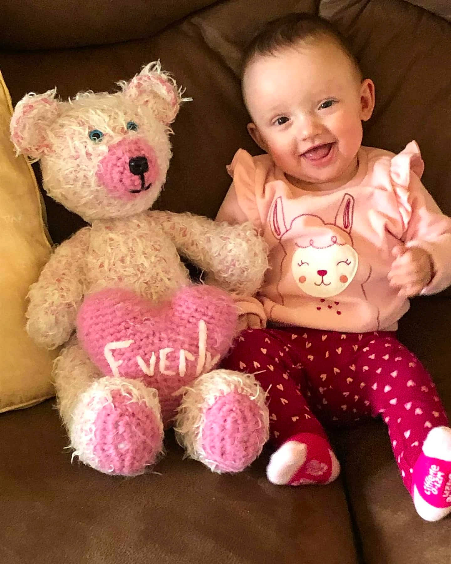 Everly is registered to the contest to win money with this photo: baby, baby_toddler_clothing, cheek, child, doll, eye, fawn, happy, head, human_body, joy, magenta, person, pink, skin, sleeve, smile, stuffed_toy, teddy_bear, textile