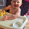 Kamryn joined the competition — help win amazing prizes! baby, high_chair, smiling, infant, food, messy, cloth, indoor, cute, child, person, happy, seat, wooden_floor, feeding, playful, young, skin, face, arm