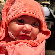 Marlo is registered to the contest to win money with this photo: baby, child, close_up, coral_color, cozy, cute, face, happy, hooded_towel, indoors, infant, kitchen, newborn, person, portrait, skin, smile, soft_texture, warm_light, wrapped