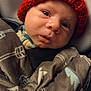 Rhyder is registered to the contest to win money with this photo: baby, blanket, car_seat, child, closeup, clothing, cozy, cute, expression, face, hat, headwear, indoor, infant, knit_hat, newborn, person, portrait, warm, young