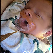 Rhyder joined the competition — help win amazing prizes! baby, blanket, child, close_up, comfort, cozy, cute, dinosaur_pattern, face, head, indoor, infant, newborn, pacifier, peaceful, resting, skin, sleeping, soft_texture, wrapped