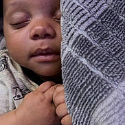 Easton is registered to the contest to win money with this photo: baby, sleeping, blanket, hand, cozy, infant, face, closed_eyes, soft_texture, comfort, cute, rest, child, warm, toddler, clothing, peaceful, portrait, skin, relaxation
