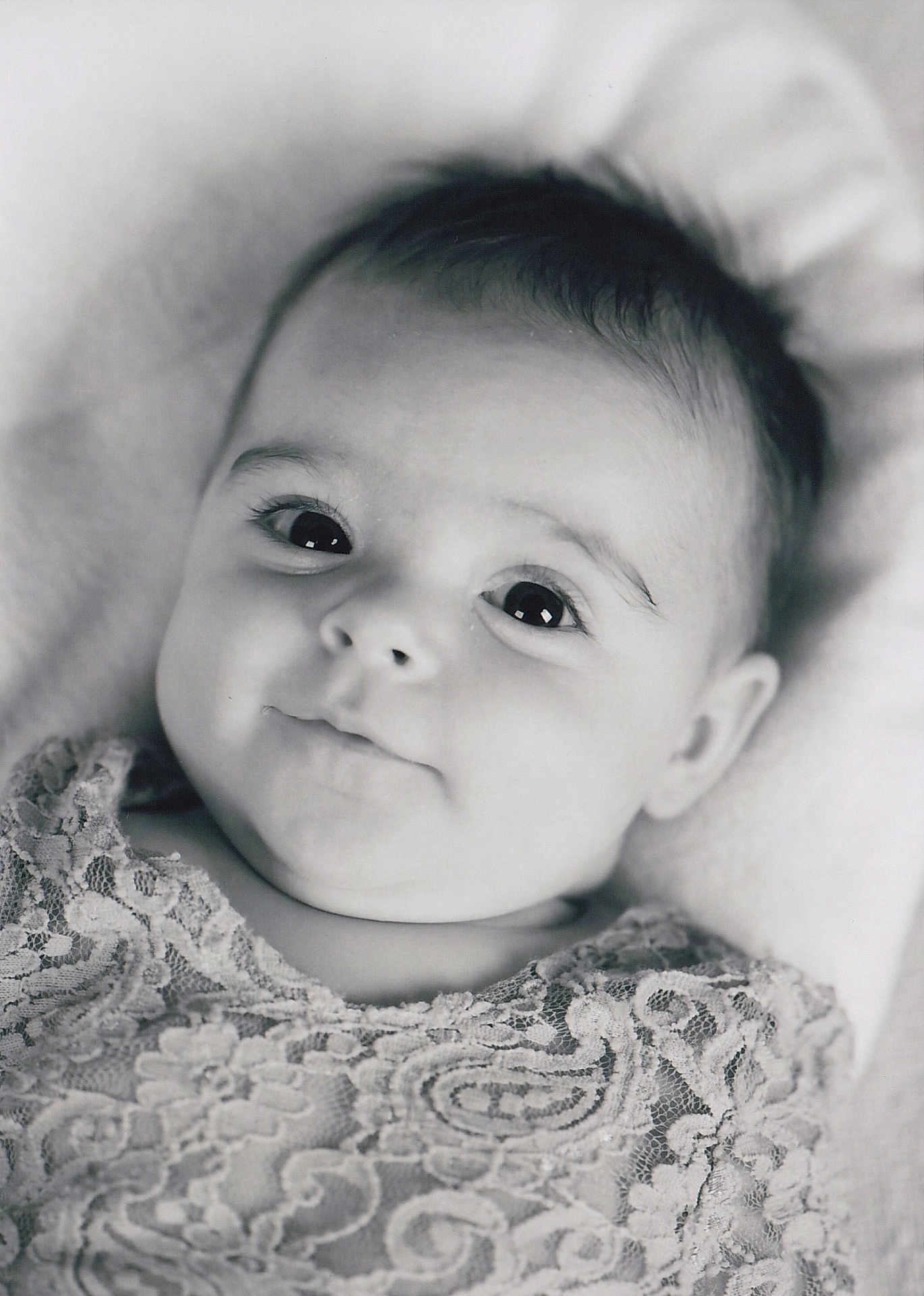 Yvana a rejoint le concours — aidez-le/la à gagner de superbes lots ! baby, infant, portrait, black_and_white, close_up, face, eyes, smile, lace, clothing, texture, soft, cute, child, young, expression, lying_down, head, innocence, monochrome