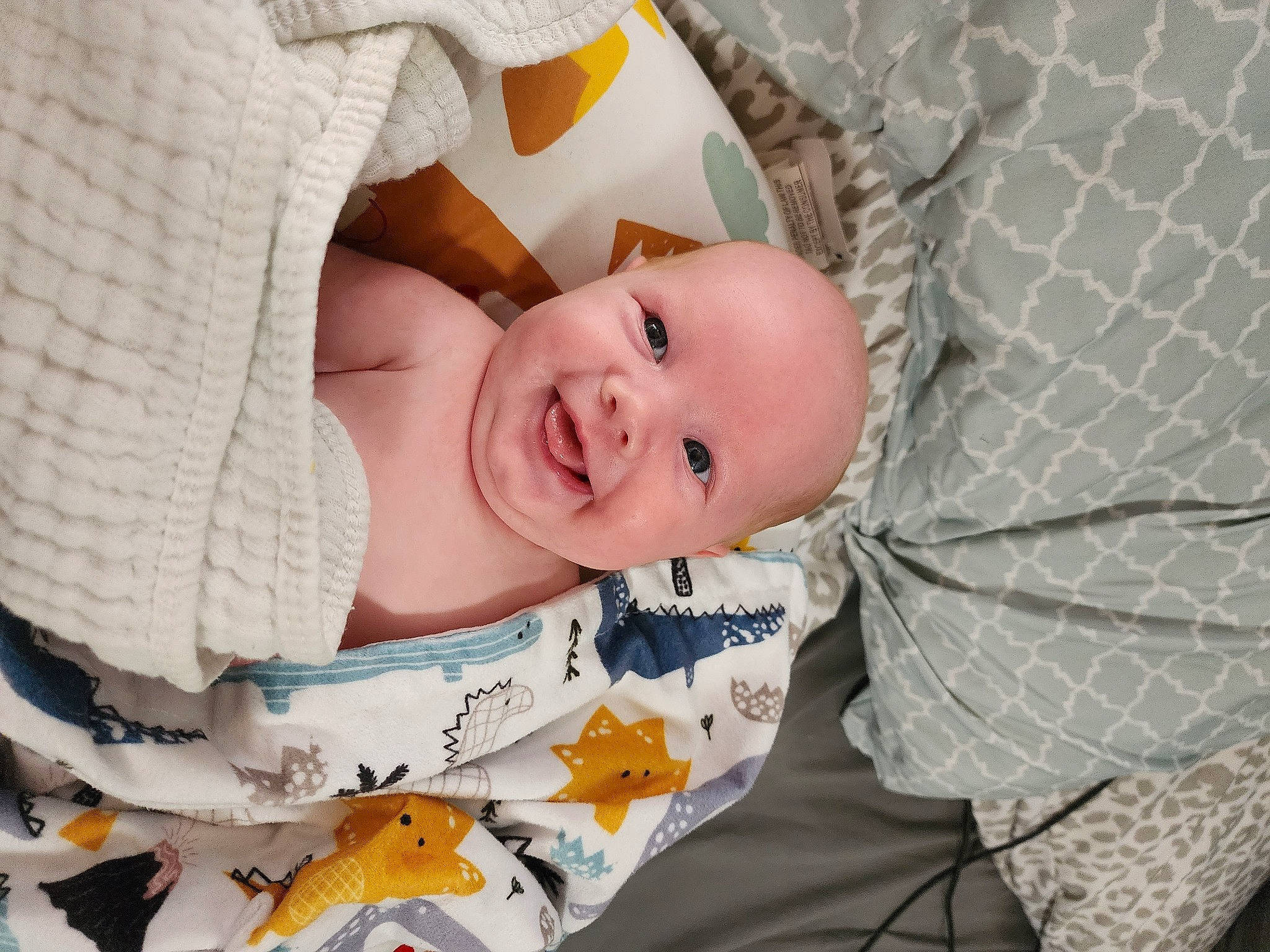 Declan is registered to the contest to win money with this photo: baby, baby_products, baby_safety, baby_toddler_clothing, cheek, child, comfort, eye, happy, head, joy, linens, pattern, person, portrait_photography, room, sitting, sleep, sleeve, smile