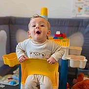 Maël participe au concours pour gagner de l'argent avec cette photo : toddler, child, yellow_chair, surprised_expression, indoor, playroom, toys, plastic_furniture, baby_clothes, person, cute, young_child, bright_colors, face, sitting, home, fun, expression, playtime, indoor_play_area