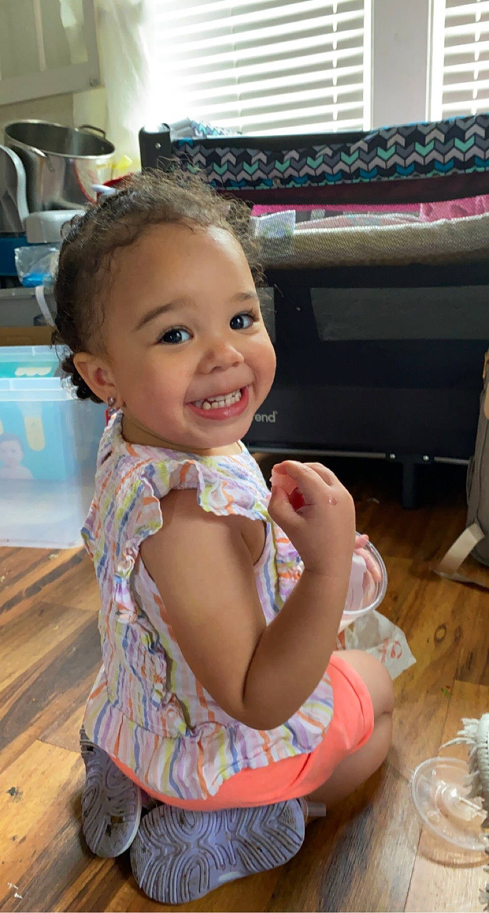 Natilee is registered to the contest to win money with this photo: baby, baby_toddler_clothing, blurred, cheek, child, eating, event, facial_expression, flooring, fun, happy, joy, leisure, nail, person, play, room, sitting, skin, smile