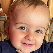 Tom a rejoint le concours — aidez-le/la à gagner de superbes lots ! baby, smiling, close_up, face, child, sweater, navy_blue, high_chair, wooden_chair, happy, cute, innocent, portrait, indoors, skin, eyes, hair, teeth, person, young_child