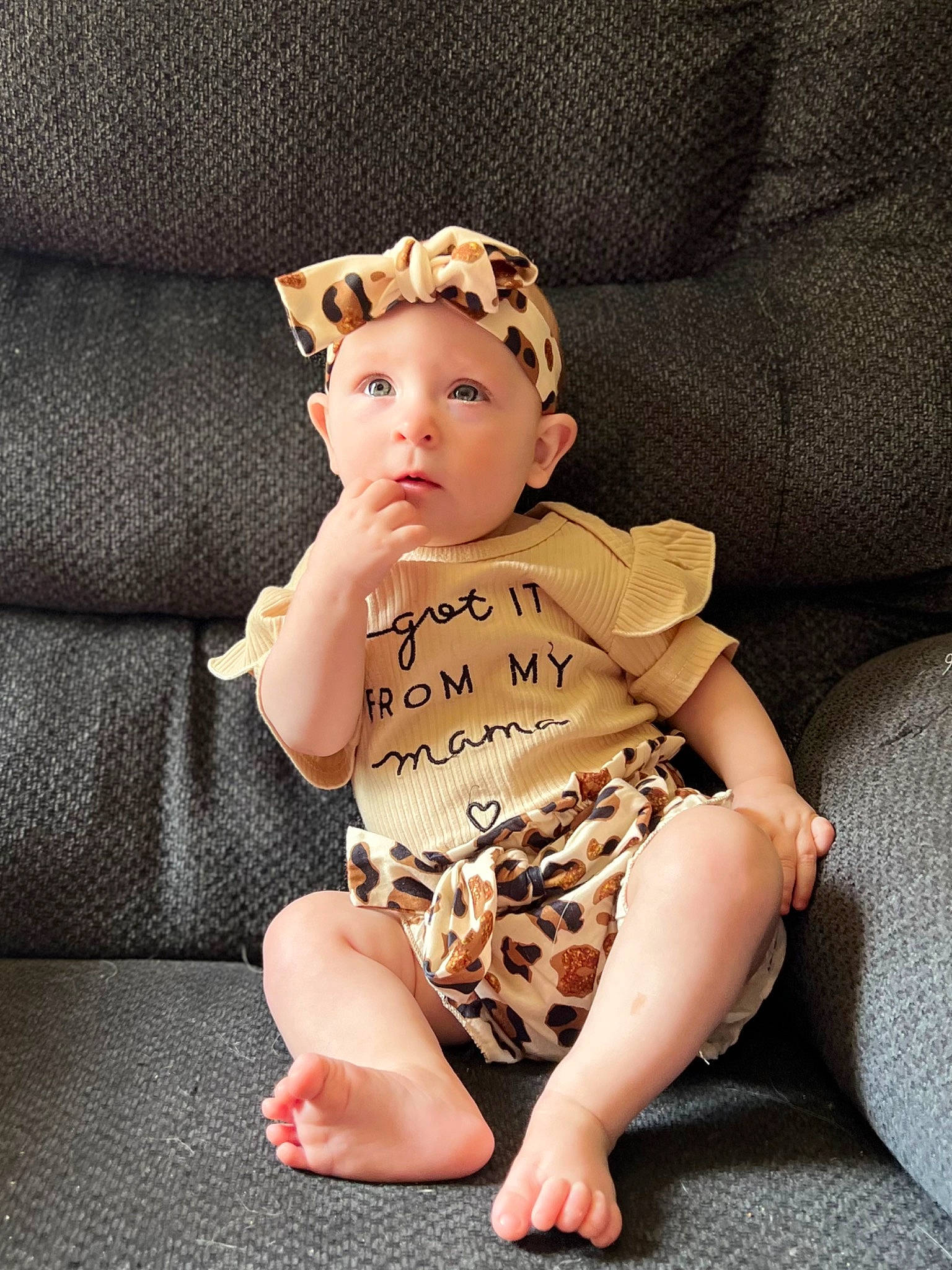 Mollie is registered to the contest to win money with this photo: baby, baby_toddler_clothing, cap, comfort, costume_hat, eye, face, foot, glasses, head, headwear, human_body, human_leg, knee, lip, pattern, person, sleeve, sock, surprise