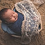 baby, sleeping, newborn, wrapped, blue_cloth, lace, wooden_bowl, texture, background, cozy, portrait, infant, peaceful, soft_light, indoors, cute, child, resting, blanket, fabric