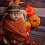 Matt is registered to the contest to win money with this photo: baby, sleeping, glasses, hat, wrapped, orange_cloth, autumn_leaves, pumpkin, basket, wooden_floor, cozy, portrait, child, fall, decor, foot, cute, indoor, seasonal, resting