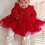 baby, child, red_dress, headband, bow, white_shoes, white_tights, blanket, indoors, serious_expression, infant, cute, fashion, portrait, sitting, tulle_skirt, footwear, headwear, person, young_child