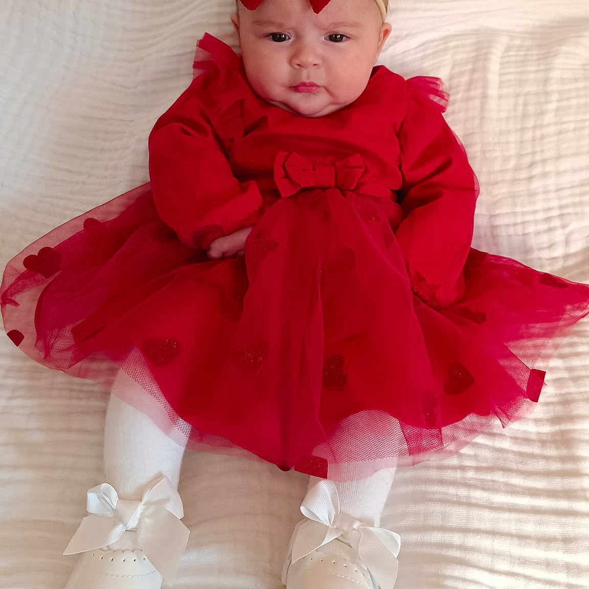 Ana Luiza a rejoint le concours — aidez-le/la à gagner de superbes lots ! baby, blanket, bow, child, cute, fashion, footwear, headband, headwear, indoors, infant, person, portrait, red_dress, serious_expression, sitting, tulle_skirt, white_shoes, white_tights, young_child
