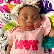 Arianna is registered to the contest to win money with this photo: baby, sleeping, pink_clothing, headband, pacifier, blanket, hearts, flowers, cute, infant, peaceful, child, closeup, adorable, soft, indoors, resting, newborn, portrait, colorful
