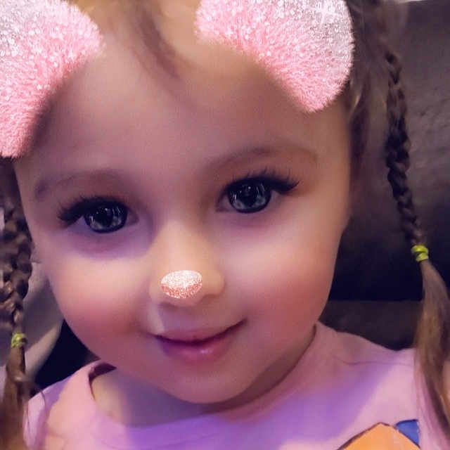Riley is registered to the contest to win money with this photo: cheek, chin, doll, dress, ear, eye, eyebrow, eyelash, forehead, hairstyle, head, iris, lip, mouth, nose, organ, pink, purple, skin, toy
